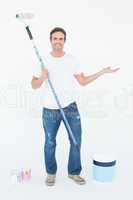 Man gesturing while holding paint roller