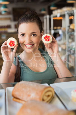 Pretty brunette showing a cupcake