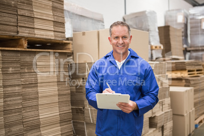 Warehouse worker checking his list on clipboard