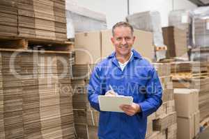 Warehouse worker checking his list on clipboard