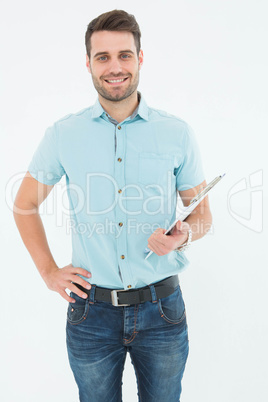 Confident young delivery man holding clipboard