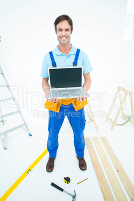 Portrait of repairman holding laptop