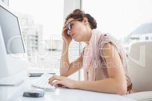 Focused businesswoman with glasses using computer
