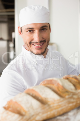 Happy baker taking out fresh loaf