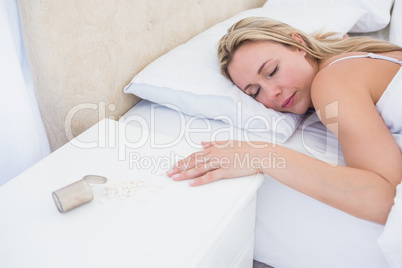 Blonde woman lying motionless in bed after overdose