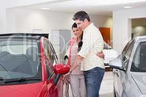 Couple talking together while looking at car