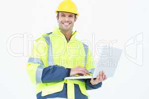 Male architect in reflective clothing using laptop