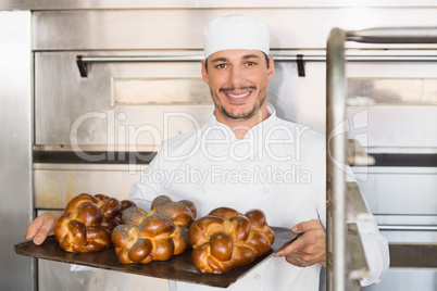 Happy baker showing tray of fresh bread Happy baker showing tray of fresh bread