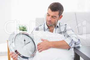 Anxious man beside a clock