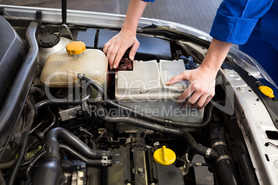 Mechanic examining under hood of car