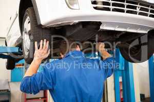 Mechanic examining under the car