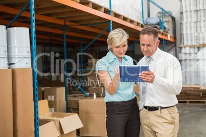 Warehouse managers looking at tablet pc