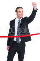 Happy businessman with clenching fist crossing the finish line