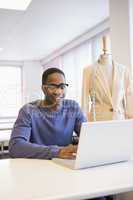 Smiling university student using laptop