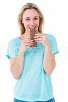 Smiling blonde eating bar of chocolate