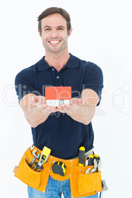 Male architect holding model home over white background