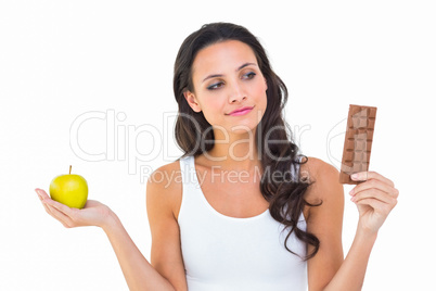 Pretty brunette deciding between apple and chocolate