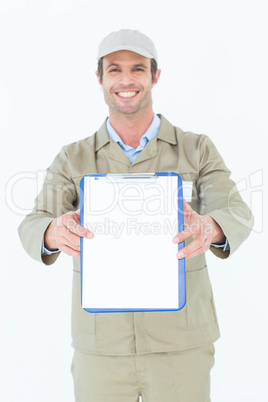 Happy delivery man showing blank paper on clipboard