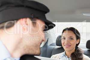 Young businesswoman being chauffeured while working