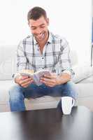 Smiling man with a mug reading a book