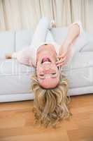 Pretty blonde lying on couch laughing on the phone