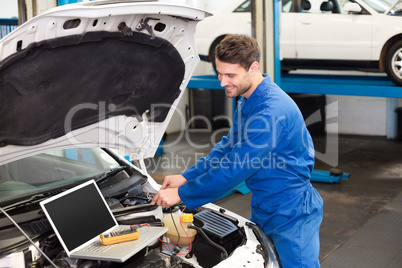 Mechanic using laptop on car