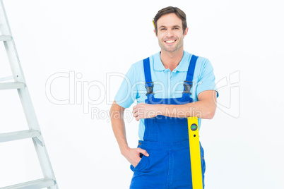 Confident carpenter leaning on spirit level