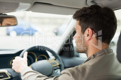 Young man looking ahead while driving