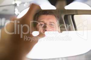 Man looking in an interior car mirror