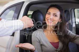 Salesman giving keys to a smiling woman