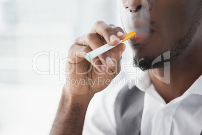 Close up of businessman smoking electronic cigarette