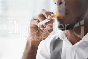 Close up of businessman smoking electronic cigarette