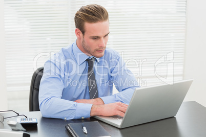 Concentrated businessman using his laptop