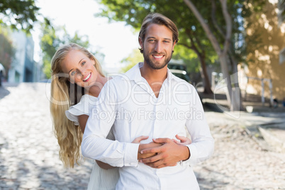 Attractive couple hugging each other and smiling at camera