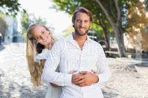 Attractive couple hugging each other and smiling at camera