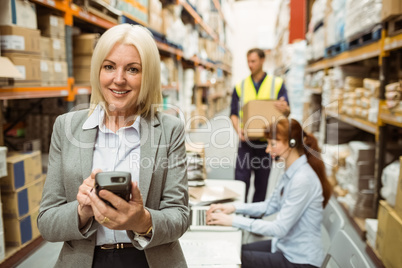 Smiling warehouse manager using handheld