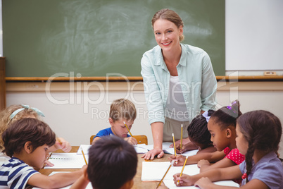 Teacher and pupils working at desk together