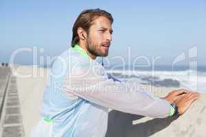 Fit man warming up on promenade