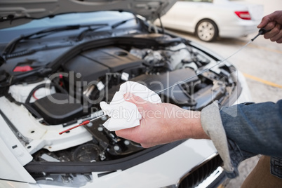 Close up of man checking car engine oil