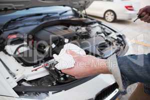 Close up of man checking car engine oil