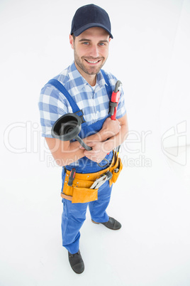 Male plumber holding plunger and wrench