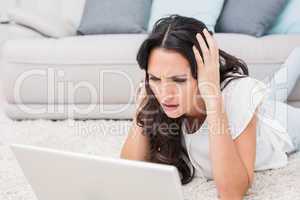 Worried brunette using her laptop