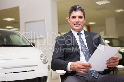 Businessman holding document at his desk