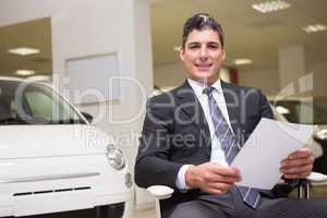 Businessman holding document at his desk
