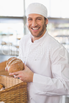 Happy baker with loaf of bread