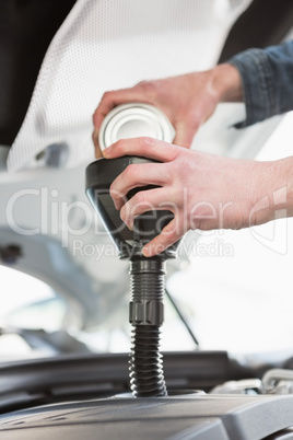 Man pouring oil into engine