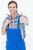 Confident plumber holding tool while gesturing thumbs up
