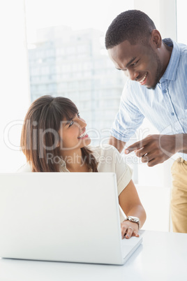 Happy coworkers using laptop together Happy coworkers using laptop together