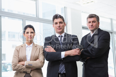 Serious business team standing with arms crossed