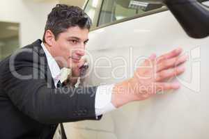 Focused businessman looking at the car body